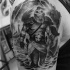 Tatuaje en el hombro, guerrero imponente en el mar y barco de vikingos