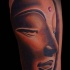 Tatuaje en el brazo, cara de buda
