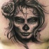 Tatuaje en el pecho, 
cara de santa muerte, color gris