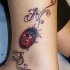 Tatuaje en el pie, mariquita con iniciales