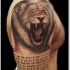 Tatuaje en el brazo, león y texto, color gris