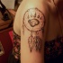 Tatuaggio tribale sul deltoide la traccia della zampa del orso su dreamcatcher