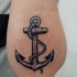 Tatuaje en el antebrazo, ancla negra metálica