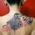 Tatuaje en la espalda,
ornamento de tintas negra y roja