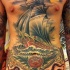 Tatuaje en el pecho y vientre, 
tema marino con barco grande en olas y pulpo con pistolas