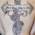 Tatuaje en la espalda,
cruz decorado con flores y inscripción