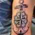 Tatuaje en el brazo, ancla preciosa con compás estilizado