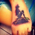 Tatuaje en el pie, silueta de sirena en la piedra