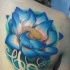 Beautiful looking colored scapular tattoo of big flower