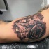 Schönes nautischthemenorientiertes schwarzes und graues Bizeps Tattoo mit Weltkarte und Kompass