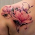 Beautiful painted and colored natural looking scapular tattoo of big flowers