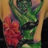 Tatuaje en el brazo,
chica zombi verde con flor