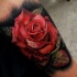 Hübsches realistisches Tattoo mit roter Rose