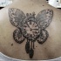 Big amazing looking upper back tattoo of butterfly wings with human heart and clock