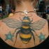 Tatuaje en la espalda, abeja y estrellas azules
