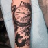 Tatuaje de reloj antiguo roto  en el antebrazo