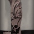Tatuaje en la pierna,
cráneo blanco en el lago oscuro