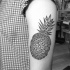 Tatuaje en el brazo, piña grande formada de figuras geométricas