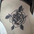 Tatuaje en el muslo,  rosa elegante monocroma