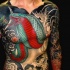grande serpente rosso verde con teschio tatuaggio su tutto il corpo