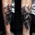 Tatuaje en el antebrazo, compás con montón de hojas, tinta negra