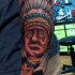 Tatuaje en el antebrazo, indio extraordinario tocado con un sombrero de plumas