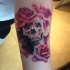 insolito colorato romantico fiori rosa con cranio tatuaggio su braccio
