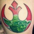 Tatuaje en la pierna,  emblema rojo de la alianza Rebelde  con cara de Yoda