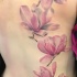 Big size delicate and tender pale pink detailed realistic flowers tattoo on woman's back