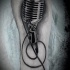 Tatuaje  de micrófono vintage en la pierna