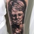 Black and gray horror style medium size boy with taped mouth tattoo on forearm