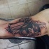 Schwarzes und graues Bizeps Tattoo  mit weiblicher Pistole