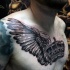 Black and gray style colored chest tattoo of crown with crow