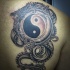 Black and gray style colored shoulder tattoo of Yin Yang symbol with dragon
