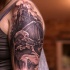 Black and gray style creepy looking shoulder tattoo of old cathedral with skeleton and human