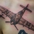 Black and gray style detailed chest tattoo of military plane