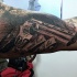 Black and gray style detailed looking biceps tattoo of great revolver and lettering