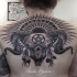 Black and gray style detailed upper back tattoo of cool demonic skull with sun and symbols