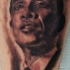 Black and gray style detailed young Obama face tattoo on leg
