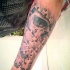 Black and gray style forearm tattoo of puzzle picture stylized with human skull