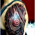 Schwarzes und rotes biomechanisches Tattoo an der Schulter