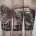 Black and white forearm tattoo of forest trees