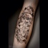 Black and white human skull with flowers tattoo on forearm length