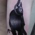 Black and white shoulder tattoo of crow hanging on arm