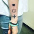 Tatuaje en el antebrazo, taza, libro abierto y avión