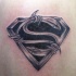 Black and white Superman's emblem stylized with bribed wire tattoo on shoulder