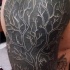 Tatuaje en el brazo, árbol grande excelente en el fonde negro