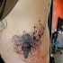 Tatuaje en las costillas, abeja con panal, diseño estilizado