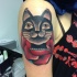 Tatuaggio colorato sul deltoide il gatto nella rosa rossa