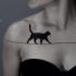 Tatuaje en el pecho, gato negro camina en hilo estirado